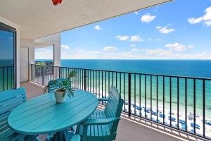 een tafel en stoelen op een balkon met uitzicht op de oceaan bij Phoenix 10 Unit 1514 in Orange Beach