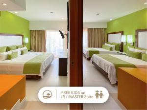 una habitación de hotel con 2 camas y un cartel para niños gratis en mi suite principal en Cancun Bay All Inclusive Hotel, en Cancún