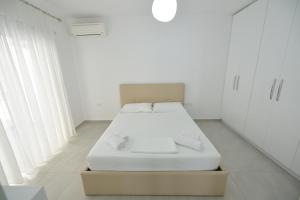 a white room with a bed and white cabinets at Aparthotel Miramare in Sarandë