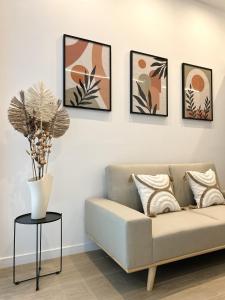 ein Wohnzimmer mit Sofa und vier Bildern an der Wand in der Unterkunft Estudio a Estrenar a metros de los Jardines del Turia in Valencia