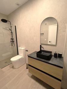 a bathroom with a sink and a toilet and a mirror at Estudio a Estrenar a metros de los Jardines del Turia in Valencia