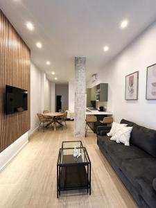 - un salon avec un canapé noir et une table dans l'établissement Estudio a Estrenar a metros de los Jardines del Turia, à Valence