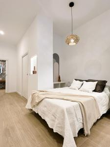 - une chambre blanche avec un grand lit et un lustre dans l'établissement Estudio a Estrenar a metros de los Jardines del Turia, à Valence