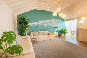 a living room with a white couch and a blue wall at Praia FLH Hotels Ericeira in Ericeira