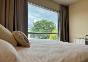 una camera con un letto e una grande finestra di Roomie Salta by DOT Suites a Salta