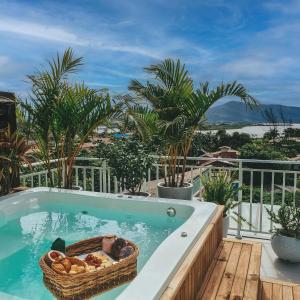 a swimming pool with a basket of bread in it at Villa Verde Bangalô - Garopaba - SC in Garopaba