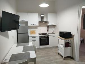 a small kitchen with white cabinets and a table at Town Center Apartment in Cagliari