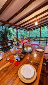 a wooden table with plates on top of it at Pincoya- Private Tropical House near Playa Chiquita Beach in Punta Uva +14 photos