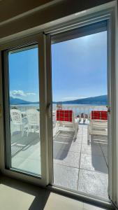 een balkon met uitzicht op een tafel en stoelen bij Family House with pool & sea view in Bijela