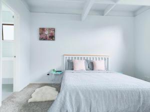 biała sypialnia z łóżkiem z białym kocem w obiekcie Sunny Cosy Room with private bathroom in North shore 201 w Auckland