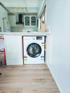 a washer and dryer in a kitchen at Sunny Cosy Room with private bathroom in North shore 201 in Auckland