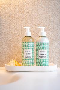 two bottles of disinfectants are sitting on a shelf at Praia FLH Hotels Ericeira in Ericeira