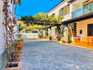 Villa Arco في بالينورو: ساحة حجرية مع ممر وطاولات وكراسي