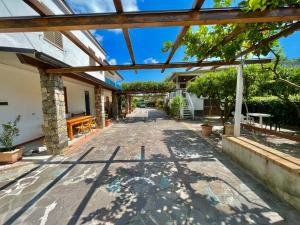 Villa Arco في بالينورو: ممشى في وسط منزل به مظلات