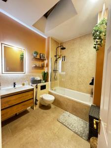 a bathroom with a tub and a toilet and a sink at Finnstown Hall in Dublin