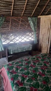 a bedroom with a bed and a window at Mahana Tua Lodge Huahine in Puahua