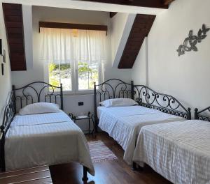 1 Schlafzimmer mit 2 Betten und einem Fenster in der Unterkunft BUJTINA Valbonë in Valbonë