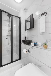 a white bathroom with a shower and a toilet at Modern 2 Bedroom Flat - Near Primrose Hill, Camden Market, Regent's Park - Good Links to Kings Cross, Euston, Finchley Road Station - NW3 London in London