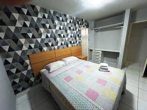 - une chambre avec un lit et un mur en damier dans l'établissement Saint Thomaz a beira mar de Jatiuca 4/4, à Maceió