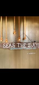 um sinal que diz mar o dia em uma parede em SEAS THE DAY Hottub Pets LOCATION beaches dining 10 star em Gibsons