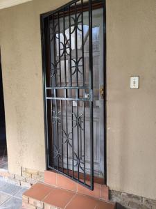 a black door with a metal gate on a building at Will's Place in Kempton Park