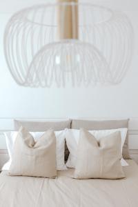 a white bed with white pillows and a chandelier at Casa da Sereia in Leiria