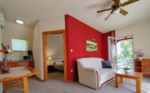 sala de estar con pared de acento rojo y silla en Hévíz Apartman Hévíz, en Hévíz