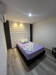 sypialnia z łóżkiem z fioletową pościelą w obiekcie Hotel Villa Sofia w mieście Villavicencio