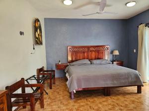a bedroom with a large bed and two chairs at Casa Xu´unan in Valladolid