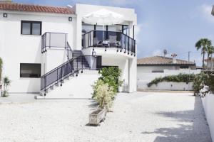 a white house with a balcony and stairs at Apartamentos Paraíso in Albir