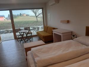 a bedroom with a bed and a couch and a table at Rooms & Wine Lilek in Šentilj