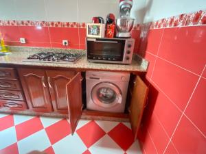 a kitchen with a microwave and a washing machine at Lina confort a tanger in Tangier
