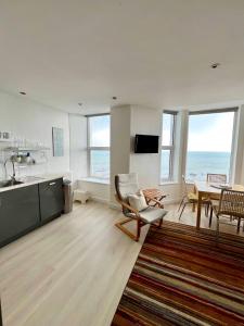 a living room with a kitchen and a dining room at Marine Terrace Apartments in Criccieth