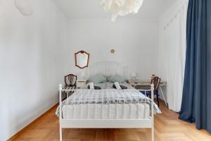 - un lit blanc dans une chambre blanche avec un bureau dans l'établissement Park Winieckiego Apartment by Grand Apartments, à Sopot