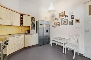 a kitchen with a refrigerator and a table and a chair at Park Winieckiego Apartment by Grand Apartments in Sopot