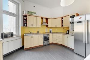 cocina con armarios blancos y nevera en Park Winieckiego Apartment by Grand Apartments en Sopot
