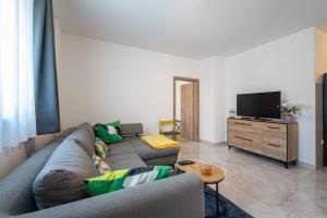 a living room with a couch and a tv at Apartman Jabuka - free parking in Karlovac