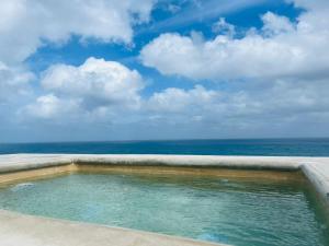 a swimming pool with the ocean in the background at Brand new penthouse with plunge pool, amazing top view in Isla Mujeres