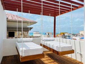 a balcony with four swinging beds and a view of the ocean at Brand new penthouse with plunge pool, amazing top view in Isla Mujeres