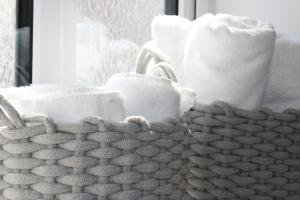 a basket of towels and toilet paper in a bathroom at Plush Peterborough in Peterborough