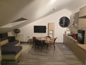 a living room with a dining table and a kitchen at Angela's Attic in Voghera
