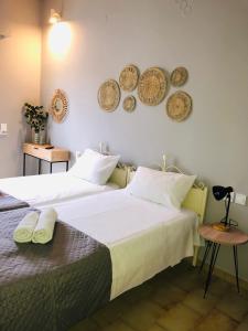 2 camas en una habitación con platos en la pared en Marina rooms, en Argostoli