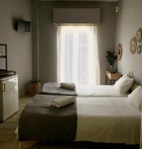 two beds in a room with a window at Marina rooms in Argostoli