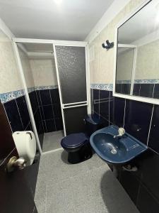 a bathroom with a blue sink and a toilet at Hotel Villa Sofia in Villavicencio