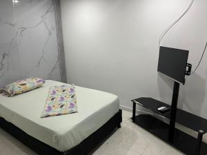 1 dormitorio con 1 cama y TV en una mesa en Hotel Villa Sofia en Villavicencio