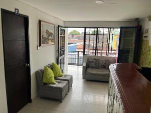 a living room with two chairs and a couch at Hotel Villa Sofia in Villavicencio