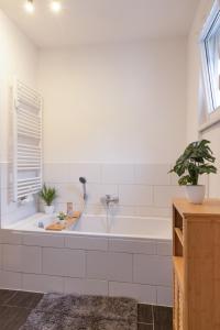 a bath tub with two potted plants in a bathroom at Apartment Sängerstadt Flat Peter in Finsterwalde