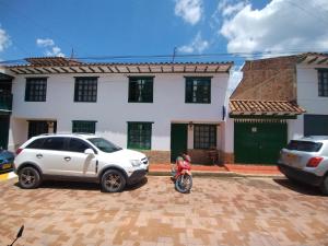 een persoon op een motorfiets geparkeerd voor een huis bij ALMANIK VIAJERO in Villa de Leyva