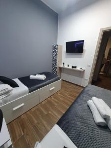 a bedroom with two beds and a flat screen tv at My Dream House 386 in Angri