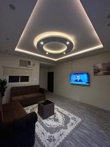ein Wohnzimmer mit einem Sofa und einem Flachbild-TV in der Unterkunft شقق لمسات in Al-'Ula